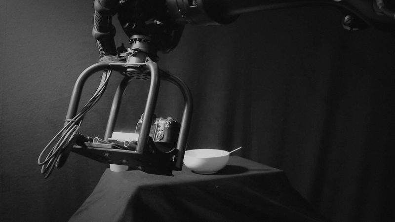 High-speed motion-control camera platform in a studio, video still, dark-graded