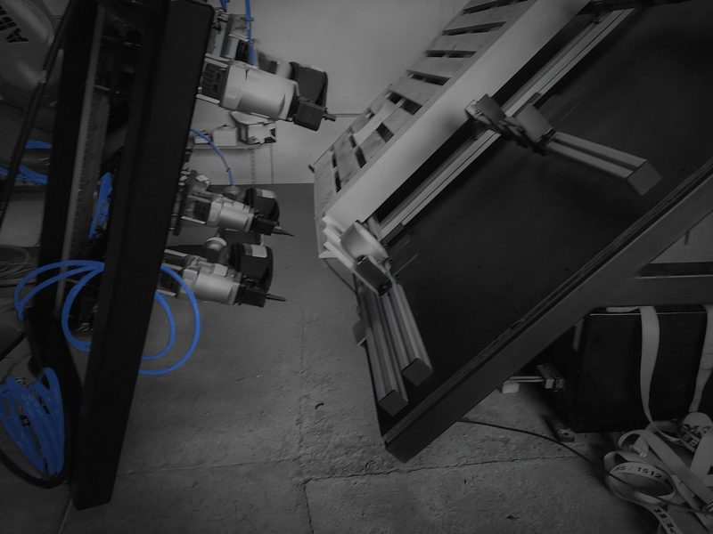 Teaching the tool centre point of the robot's end effector next to the turntable rig, dark-graded